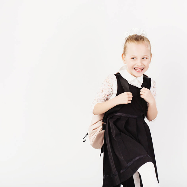 Graciosa niña sonriente con gran mochila saltando y teniendo f
 - Foto, imagen