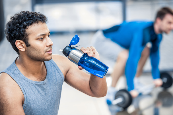 człowiek z butelka wody odpoczynku w siłowni - Zdjęcie, obraz