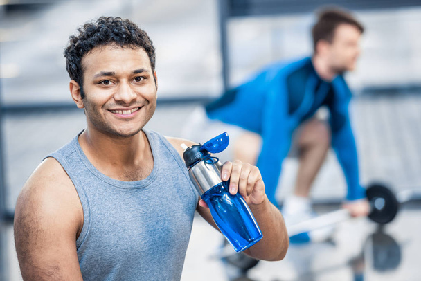 homme avec bouteille d'eau reposant à la salle de gym
 - Photo, image