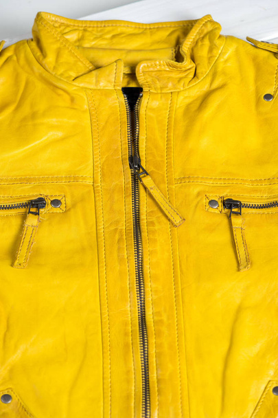 Yellow leather jacket zippers and pockets. Macro leather jacket details - Zdjęcie, obraz