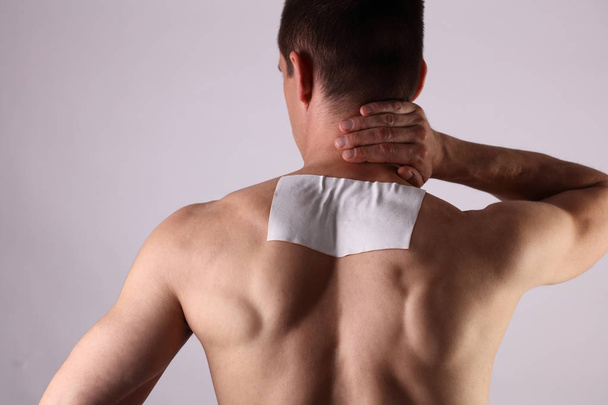 Medicated pain relief patch, plaster. man with back pain. Pain relief and health care concept. - Foto, imagen