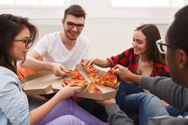 Студенты делятся пиццей на домашней вечеринке
 - Фото, изображение