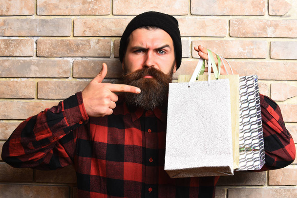 Bearded brutal caucasian hipster with moustache holding shopping packages - Photo, image