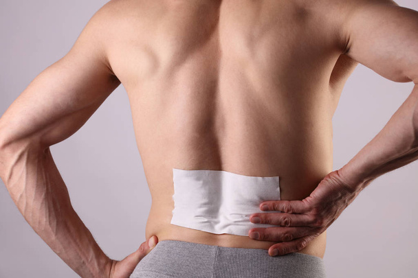 Medicated pain relief patch, plaster. man with back pain. Pain relief and health care concept isolated on white. - Φωτογραφία, εικόνα