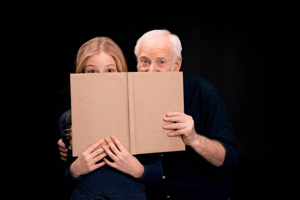 grandfather and granddaughter holding book - Φωτογραφία, εικόνα