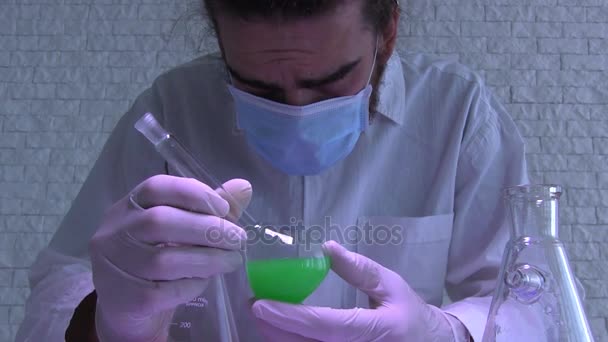 Młody naukowiec jest zbadanie reakcji chemicznej. Badania w laboratorium. Test laboratoryjny - Materiał filmowy, wideo
