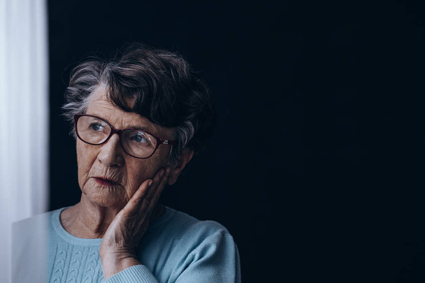 Old woman in dark room - Valokuva, kuva
