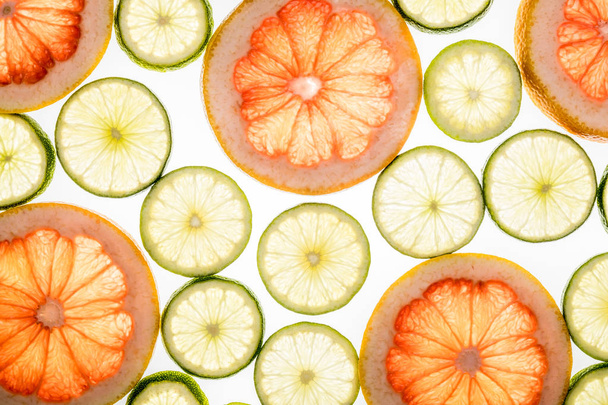 Bright lime and grapefruit slices on white - 写真・画像