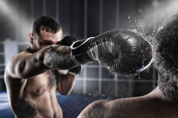 Boxer σε ένα boxe ανταγωνισμό κτυπά τον αντίπαλό του - Φωτογραφία, εικόνα