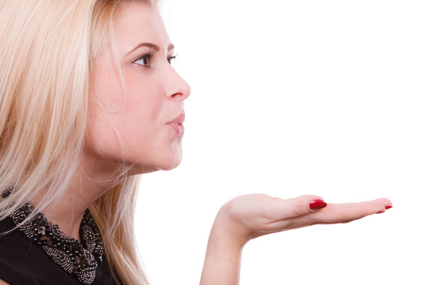 Blonde woman sending air kiss on palm hand - Foto, Imagen