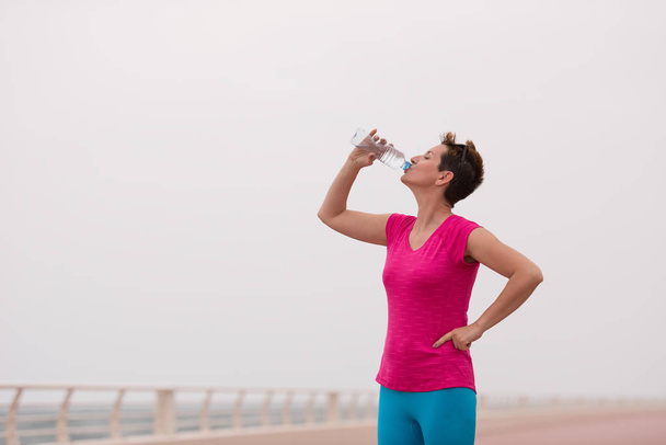 Fitness woman drinking water - Foto, afbeelding
