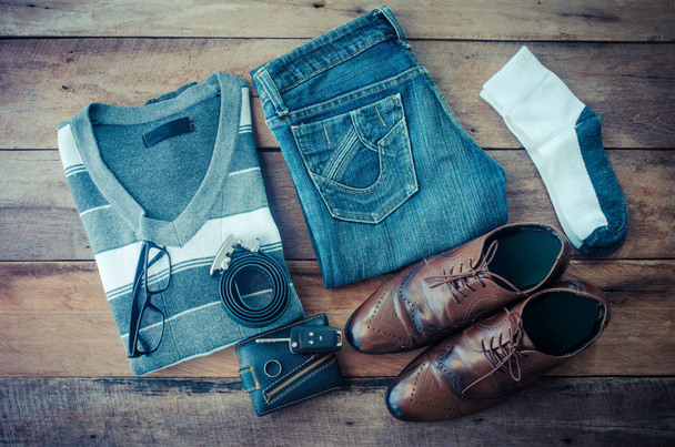 Maglioni, jeans, calzini, scarpe, cinture, portafogli, occhiali da sole, pronti per il viaggio. - Foto, immagini