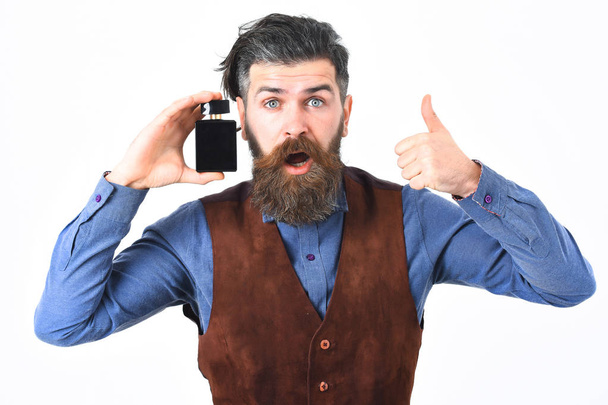 bearded man holding perfume with surprised face - Foto, Imagem