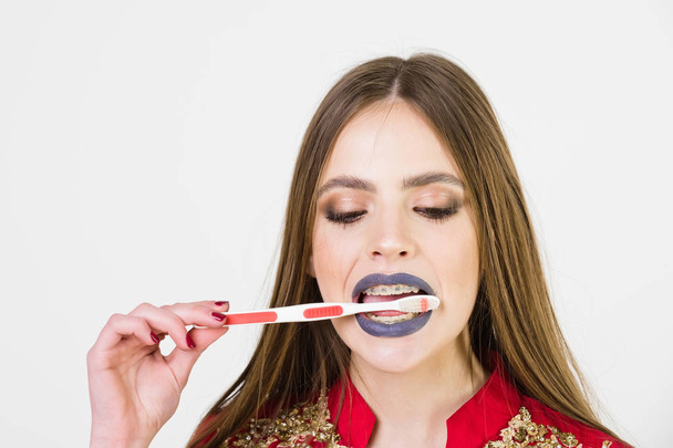 girl with teeth braces and brush, has fashionable makeup - Foto, Imagen