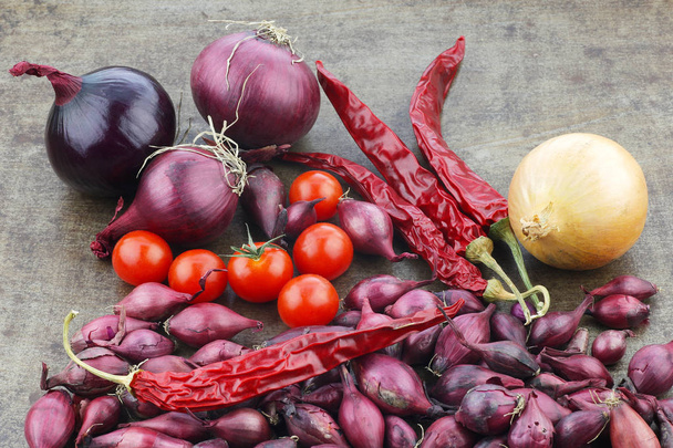  Farbenfrohe Präsentation von Zwiebeln, Tomaten und getrockneten Chilischoten - Foto, Bild