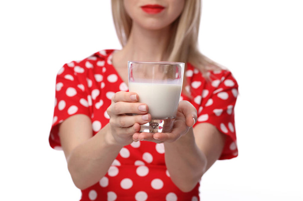 Woman holding or giving glass of milk. Selective focus on glass of milk. Dairy products concept - Фото, изображение