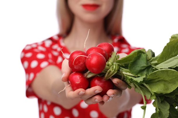 Женщина держит свежие органические овощи редис на белом фоне. Диета, здоровое питание и образ жизни
. - Фото, изображение