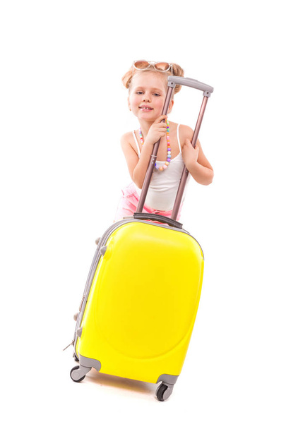 Μικρό ξανθό κορίτσι με κίτρινο suicase - Φωτογραφία, εικόνα