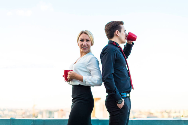 Couple of businesspeople with coffee on roof - Photo, Image