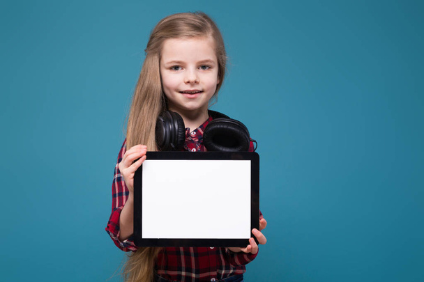 Menina em fones de ouvido segurando tablet vazio
 - Foto, Imagem