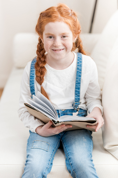 маленькая девочка читает книгу  - Фото, изображение