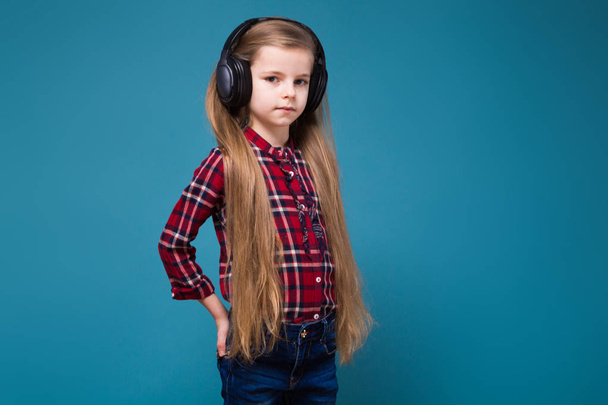 Little girl in plaid shirt and headphones - Foto, afbeelding