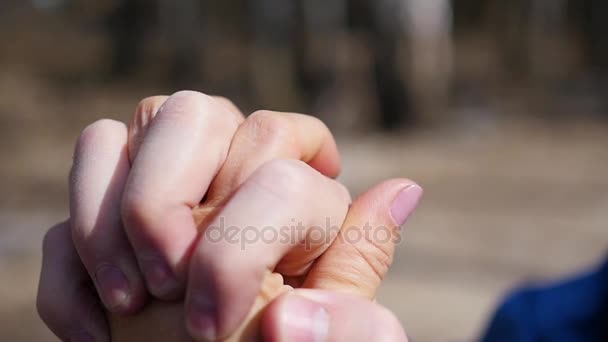 Close-up van twee liefhebbers toetreden handen. Detail silhouet van Man en vrouw bedrijf overhandigt. Liefde en geluk concept. - Video