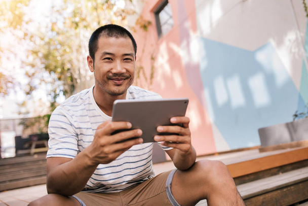  man smiling and using digital tablet - Photo, Image