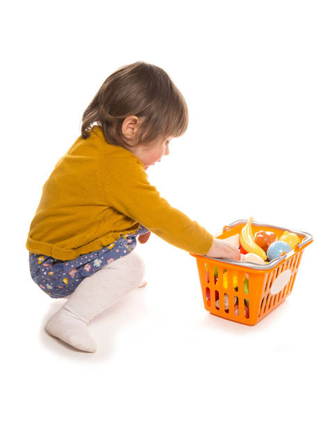 niño jugando con comida plástica
 - Foto, Imagen