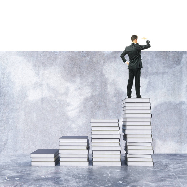 Молодой бизнесмен на вершине креативной книжной лестницы смотрит вдаль. Концепция знаний. 3D рендеринг
 - Фото, изображение