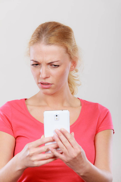 Shocked worried woman looking at phone - Zdjęcie, obraz