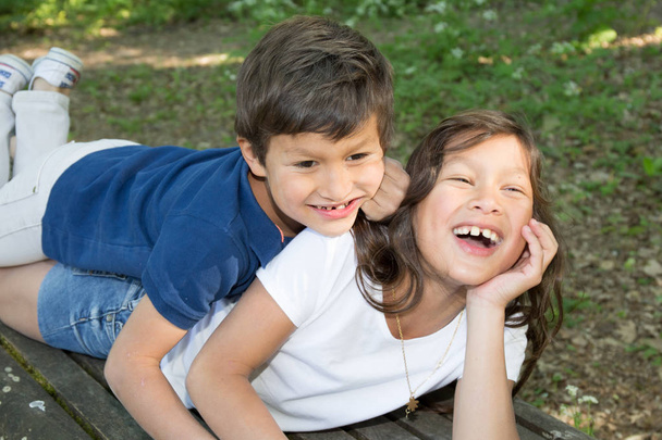 child boy lying in the grass with sister in the park - Photo, Image