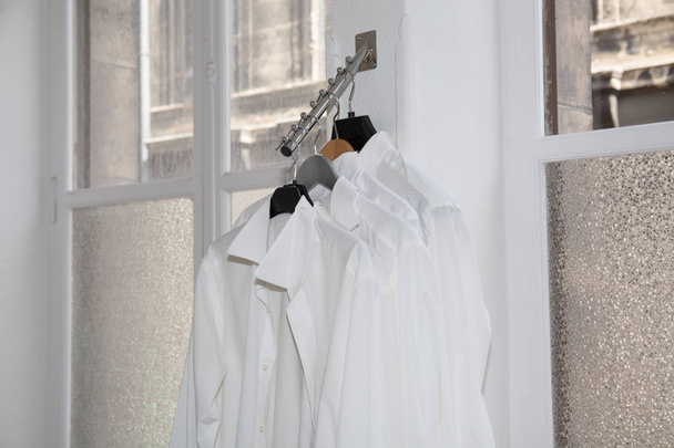 Camicie bianche pronte per essere provate in un negozio tessile
 - Foto, immagini