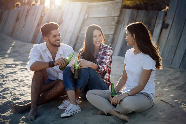 Happy people drinking at beach - Фото, изображение