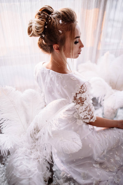 junge schöne Braut im Boho-Stil und weißen Federn. - Foto, Bild