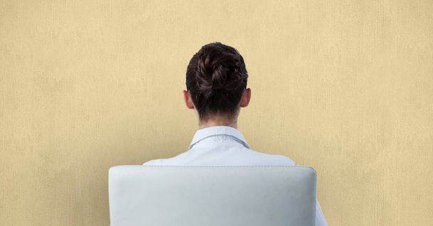 Pohled zezadu na podnikatelka sedí na židli proti zdi - Fotografie, Obrázek
