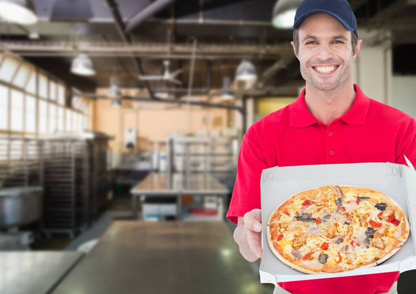 Happy deliveryman showing the pizza - 写真・画像