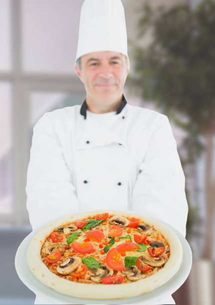 Chef with pizza in the restaurant - 写真・画像