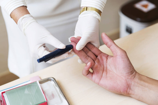 Κοντινό πλάνο, νοσοκόμα χέρια κάνουν αίμα δοκιμές σε χέρι του άνδρα - Φωτογραφία, εικόνα