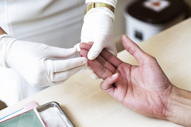 Κοντινό πλάνο, νοσοκόμα χέρια κάνουν αίμα δοκιμές σε χέρι του άνδρα - Φωτογραφία, εικόνα