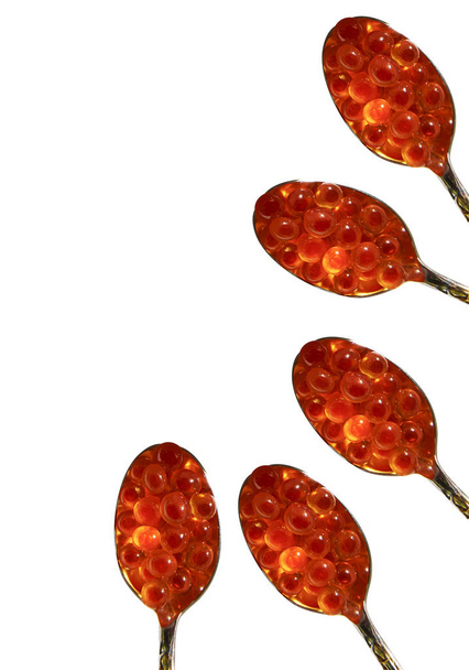 Red caviar and spoons isolated on background - Photo, Image