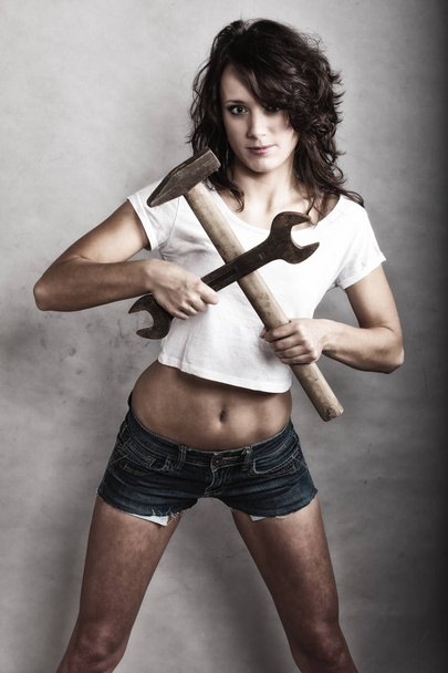 Sexy girl holding hammer and wrench spanner - Fotoğraf, Görsel