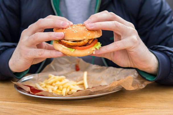 primer plano vista de mans manos con american hamburguesa
. - Foto, Imagen
