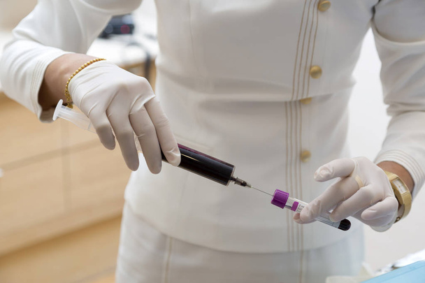 Enfermeira que tira amostra de sangue para tubo para exame de sangue
 - Foto, Imagem