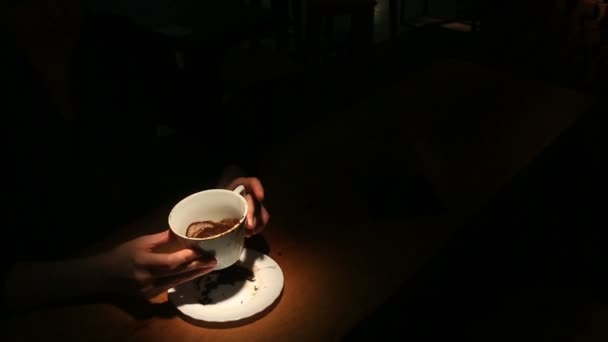 Gissen op de koffie gronden, een vrouwelijke hand met een koffiemok. Close-up. - Video