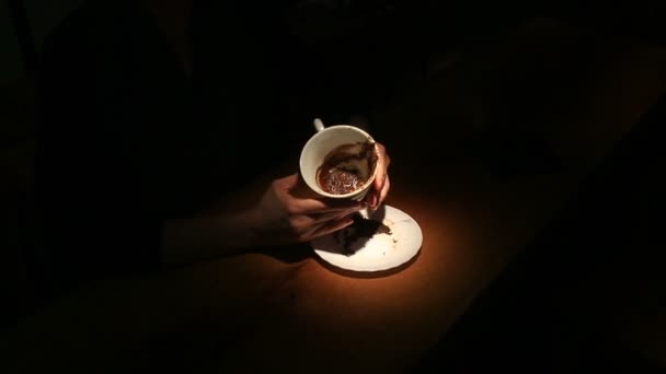 Adivinando en el café, una mano femenina sosteniendo una taza de café. Primer plano
. - Metraje, vídeo