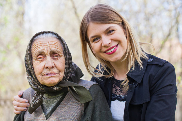 Doente mulher idosa com seu zelador ao ar livre
 - Foto, Imagem