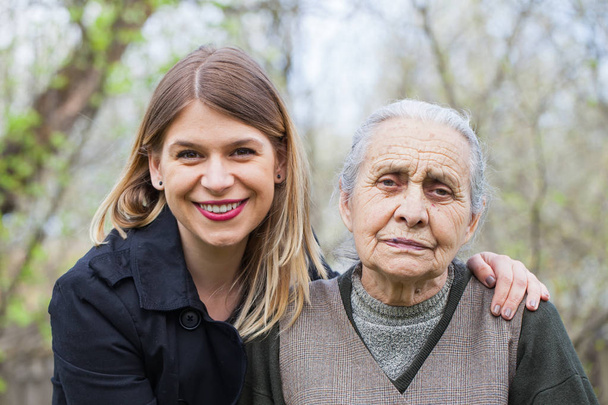 ältere Frau mit ihrer Betreuerin im Freien - Foto, Bild