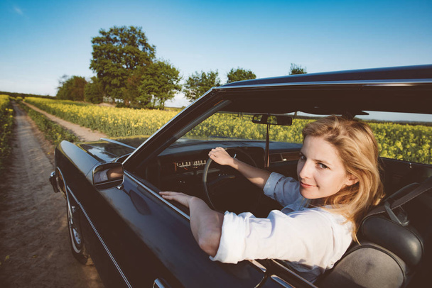 Söpö nuori nainen ajaa klassista autoa
 - Valokuva, kuva