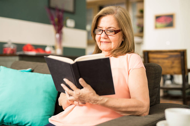Oudere vrouw genieten van haar lezing tijd - Foto, afbeelding